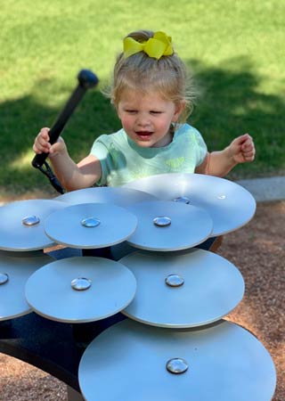 Young girl plays with musical installations in Unity Square.